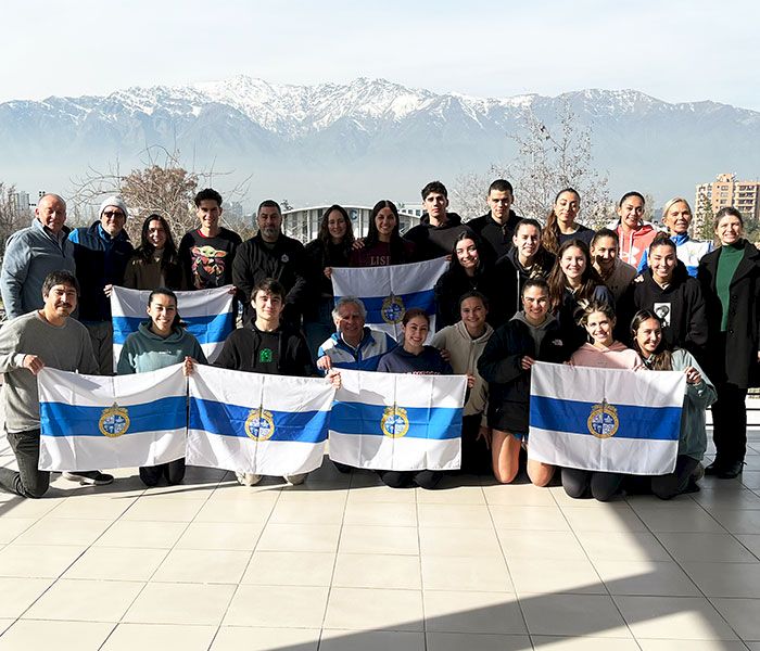 Deportistas de la UC mostrando banderas de la Universidad.