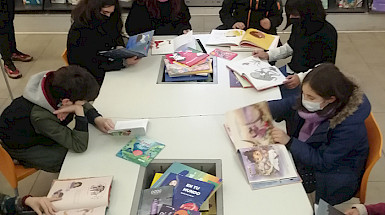Niñas y niños evaluando libros infantiles en la Biblioteca de Santiago.