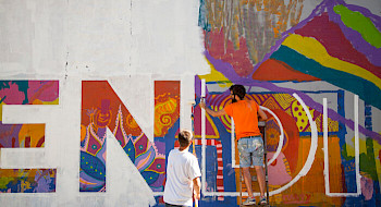 Dos hombres pintan el mural Simbiosis ubicado en la comuna de Recoleta