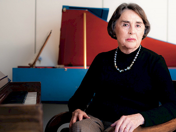 Sylvia Soublette sentada frente a un piano en su casa