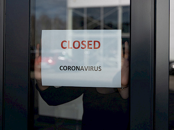 Imagen de puerta de negocio donde se lee cartel "closed"