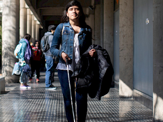 Foto de una alumna con discapacidad visual usando el piso podotáctil de San Joaquín