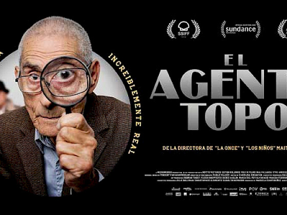 Afiche oficial película El Agente Topo. Primer plano de hombre con una lupa