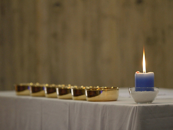 altar con mantel, patenas y vela encendida