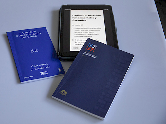 Libros impresos y digital en tablet de la propuesta constitucional.