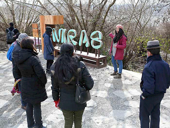 Grupo de personas frente a un cartel del Museo MIRAS