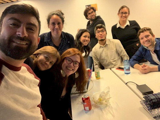 Grupo de estudiantes de doctorado sonriendo a la cámara.