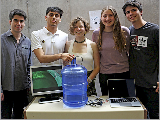 Grupo de estudiantes junto a un bidón de agua.