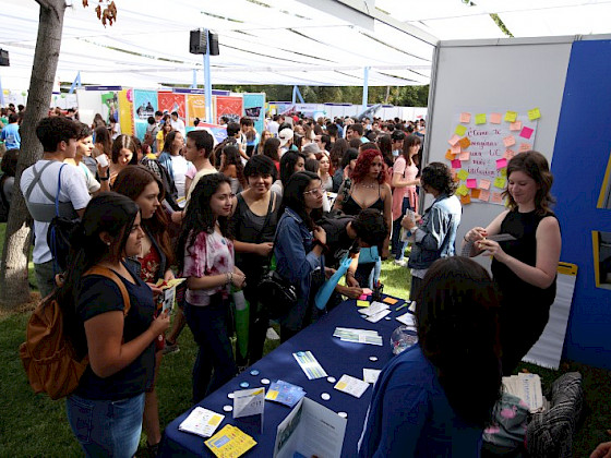 Grupo de estudiantes frente a un mesón de la Bienvenida Novata