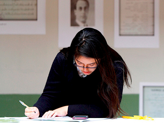 Alumna escolar escribe en un cuaderno