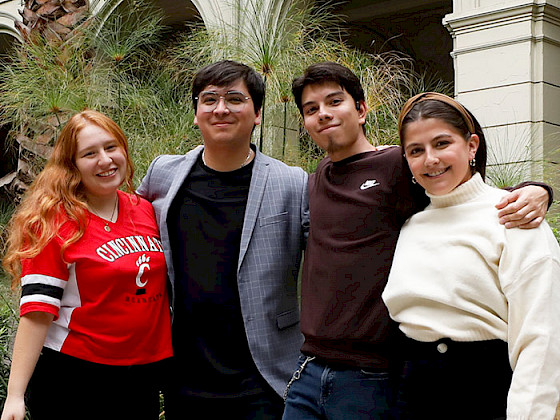 Los cuatro estudiantes becados de pie en un patio de Casa Central UC