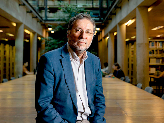 Fotografía de perfil del historiador Rafael Sagredo en una biblioteca.