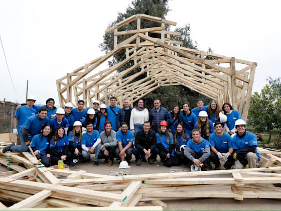 Grupo de personas frente a una capilla a medio construir.