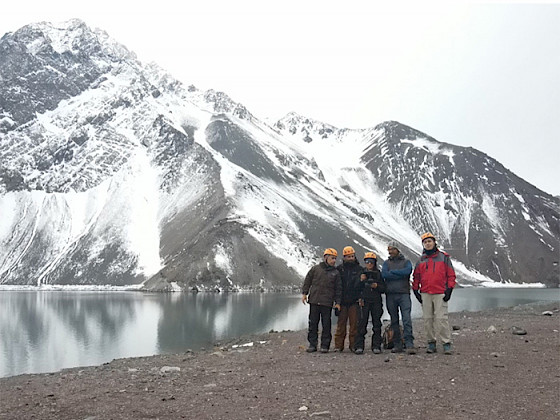 Grupo de investigadores usando cascos y ropa de terreno en el embalse el Yeso, en el Cajón del Maipo.