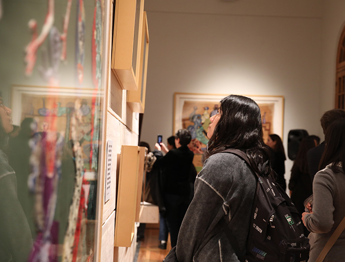 Una joven observa algunas de las obras expuestas en la muestra Casa Violeta Parra.