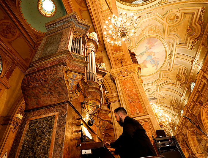 Un músico tocando un órgano en la catedral de Santiago, mirado desde abajo.