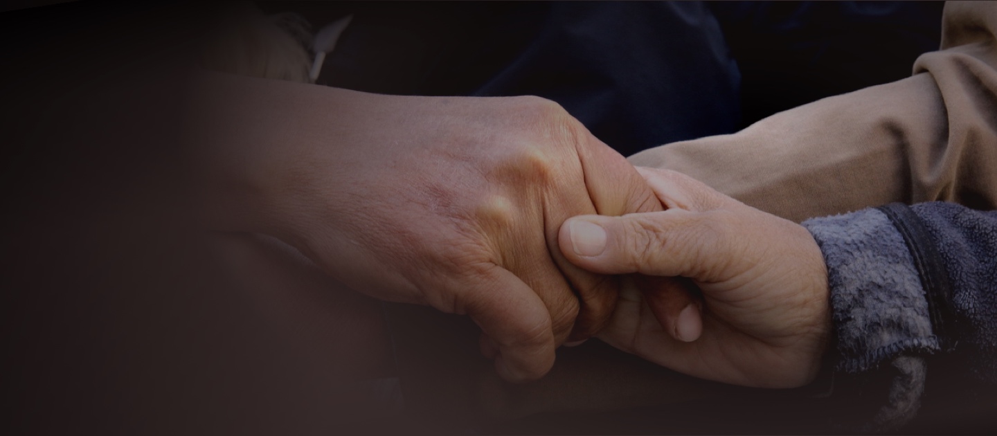 Dos manos, una de adulto y otra de niño, entrelazadas en un gesto de afecto y unión.