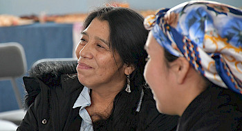 Mujer mapuche habla junto a una mujer no mapuche, en el diálogo intercultural realizado en Los Ángeles.
