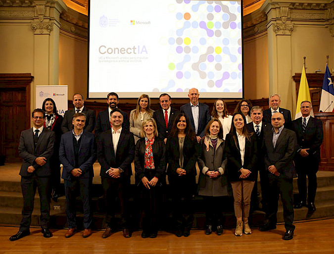 Group of UC and Microsoft executives, in a UC room, with the presentation of ConectIA in the background.