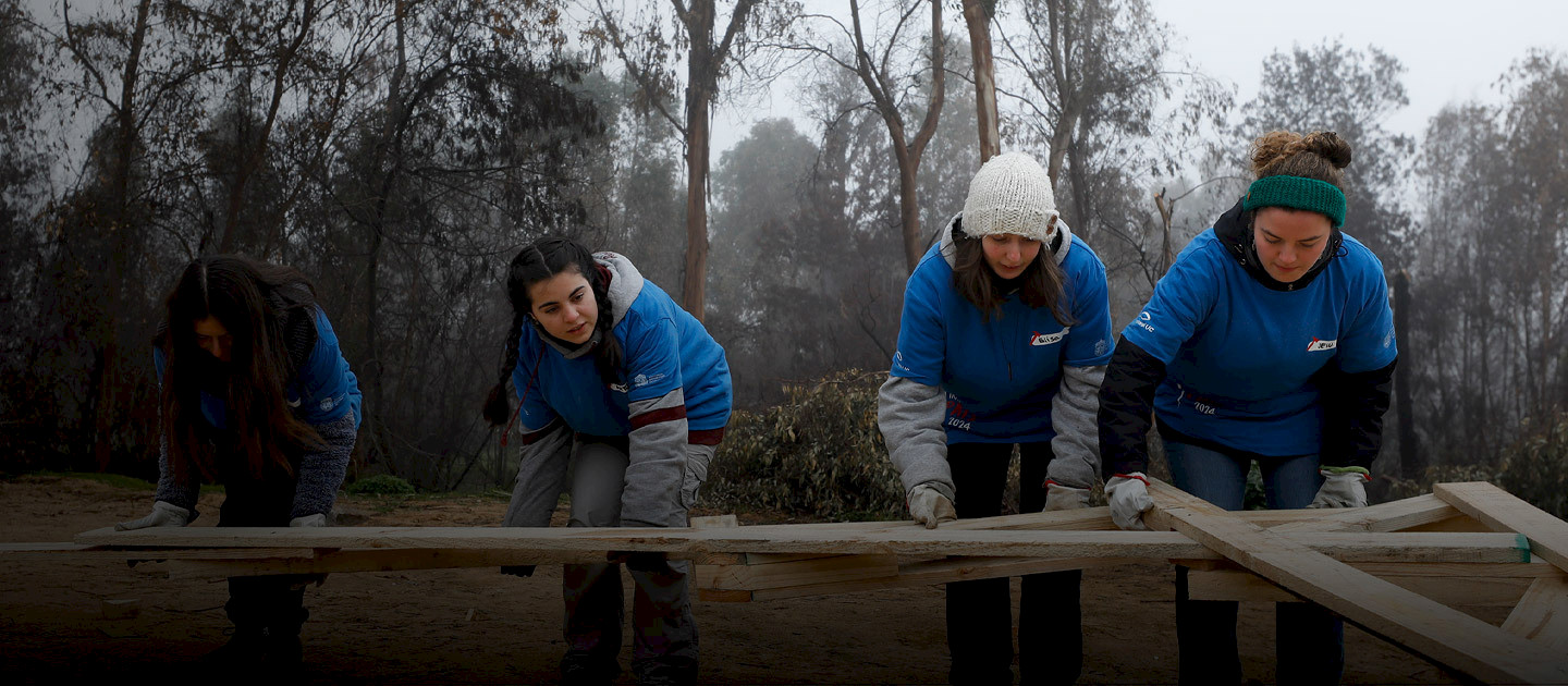 Jóvenes voluntarias de Trabajo País trabajan en una estructura de madera.