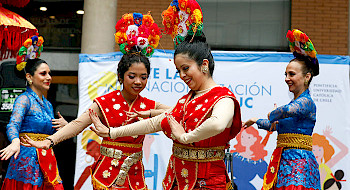 Mujeres usando coloridos trajes bailan una danza tradicional de Indonesia.