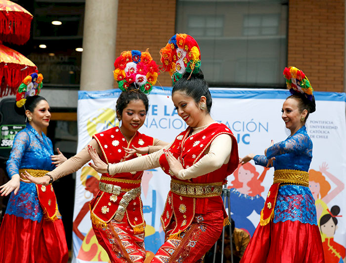 Mujeres usando coloridos trajes bailan una danza tradicional de Indonesia.