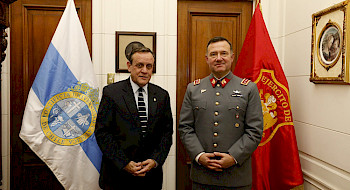 dos hombres de pie, detrás de ellos hay dos banderas