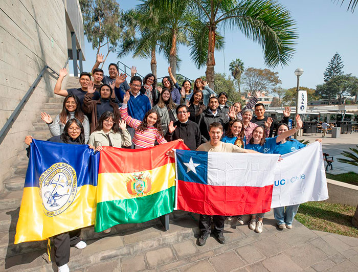 Grupo de misioneros de Chile, Bolivia y Perú, sosteniendo banderas.