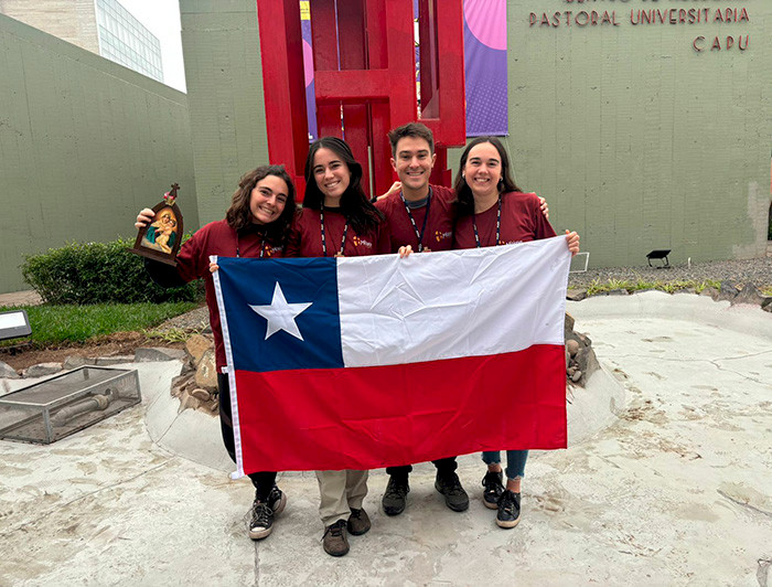 Misioneros de la UC sosteniendo una bandera chilena.