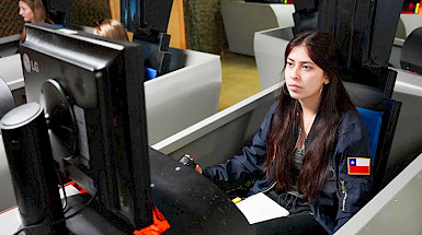 Matilde Gaete, a UC Chile engineering student, participates in a flight simulator as part of her aerospace training.