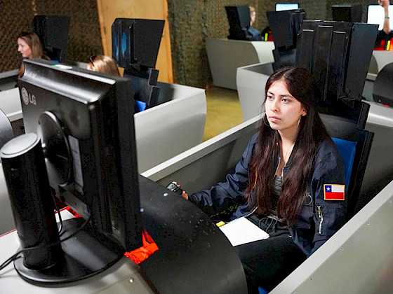 Matilde Gaete, a UC Chile engineering student, participates in a flight simulator as part of her aerospace training.