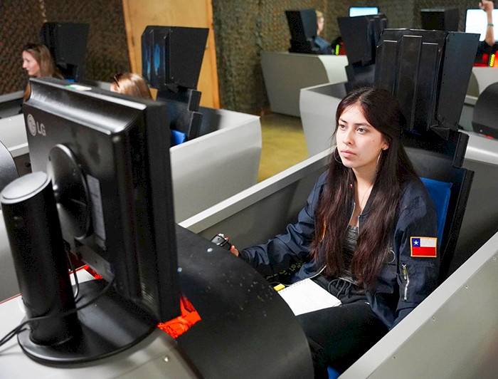 Matilde Gaete, a UC Chile engineering student, participates in a flight simulator as part of her aerospace training.