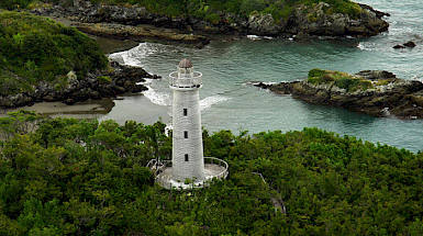 Lighthouse surrounded by lush greenery on the coast of Tantauco Park, Chiloé Island.