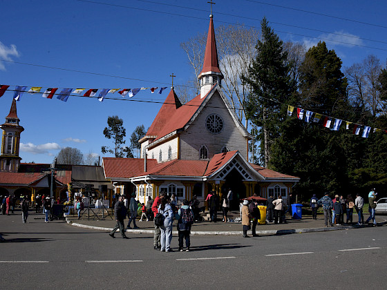 Frontis de Iglesia del Tránsito en Metrenco junto a personas en las inmediaciones.