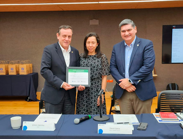 El rector Ignacio Sánchez sosteniendo un diploma junto a los rectores de Uniandes, Raquel Bernal, y David Garza, del Tec de Monterrey.