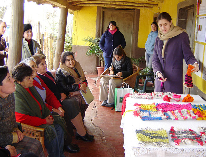 Una joven presentando trabajos textiles a la comunidad