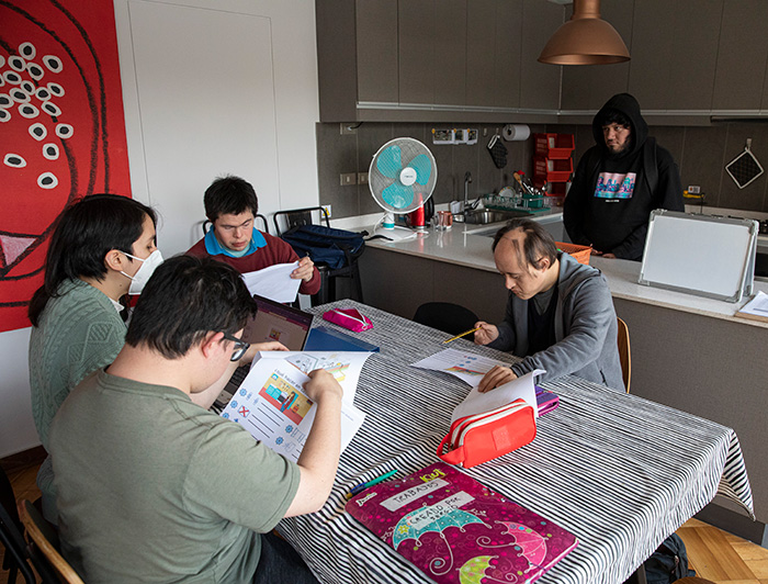 Jóvenes con síndrome de Down leyendo unas guías en la Casa Simulada. 