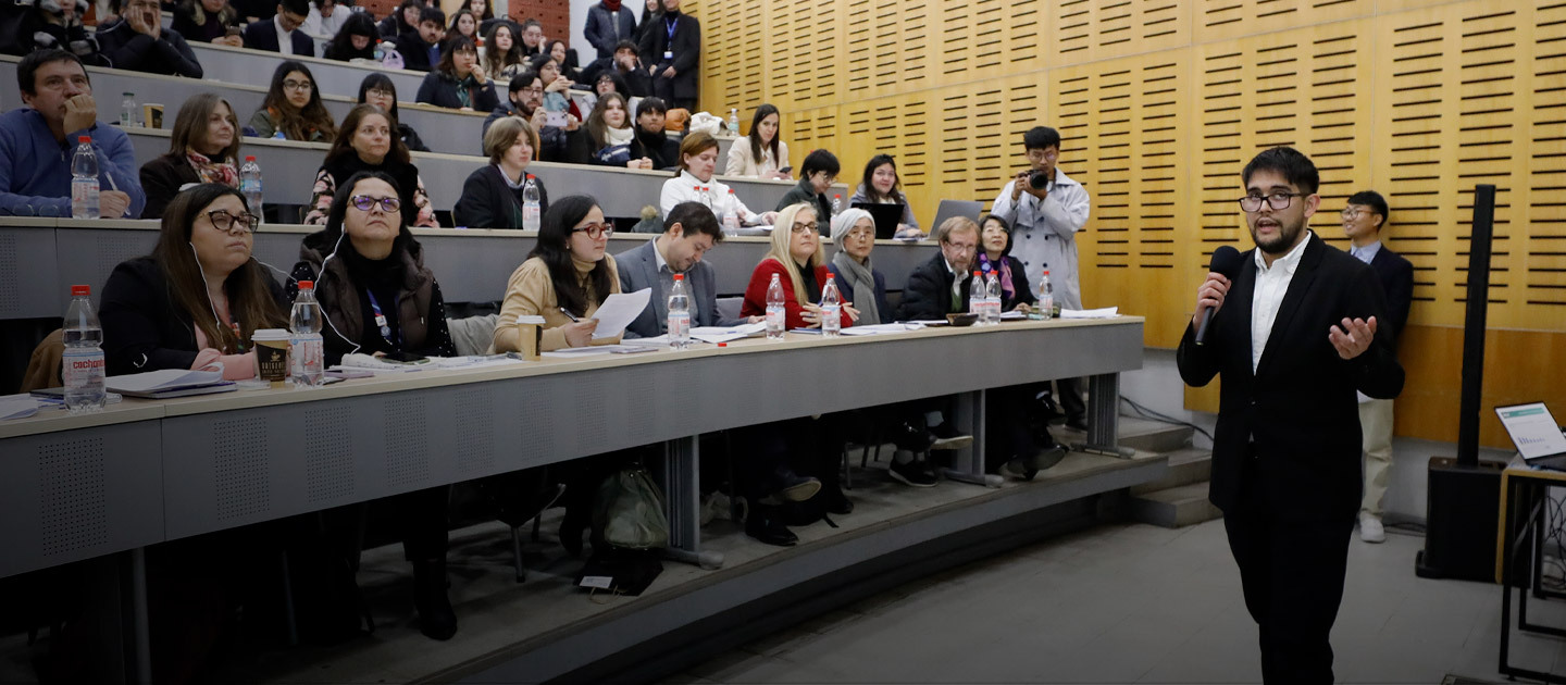 Student presenting a project to an audience and a panel of judges during the Youth Challenge to Alleviate Poverty competition at UC Chile.