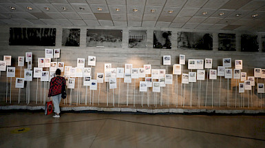 A visitor observing exhibits at the Museum of Memory and Human Rights in Chile, showcasing photographs and documents related to historical events.