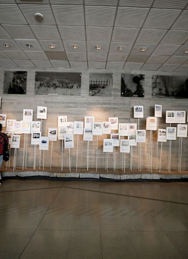 A visitor observing exhibits at the Museum of Memory and Human Rights in Chile, showcasing photographs and documents related to historical events.