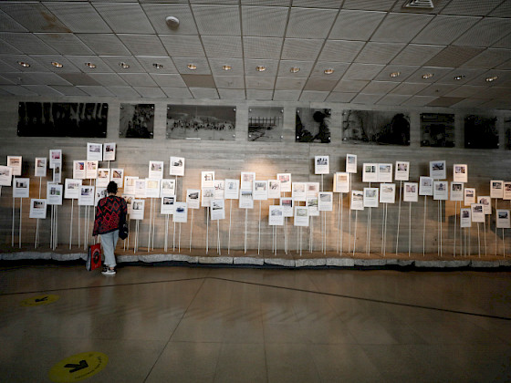 A visitor observing exhibits at the Museum of Memory and Human Rights in Chile, showcasing photographs and documents related to historical events.