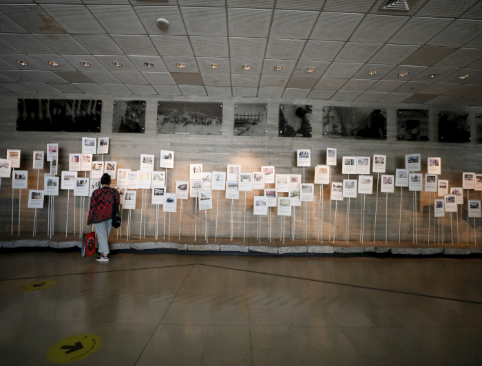 A visitor observing exhibits at the Museum of Memory and Human Rights in Chile, showcasing photographs and documents related to historical events.