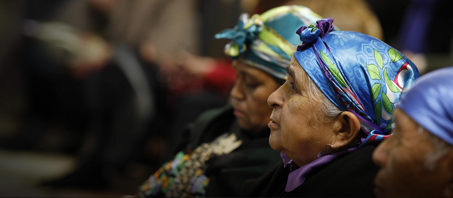 Personas del pueblo Mapuche usando pañuelos tradicionales en sus cabezas.