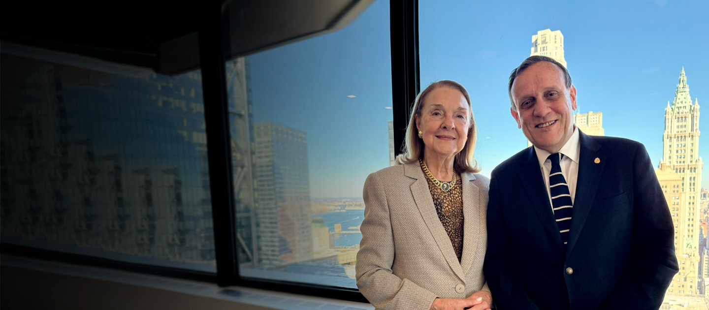 Sava Thomas, President of the Friends UC Board, and Ignacio Sánchez, Rector of UC Chile, posing together in a meeting room with New York City skyscrapers in the background.