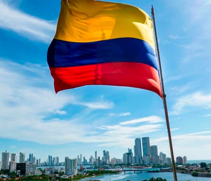 Bandera de Colombia con paisaje urbano de fondo