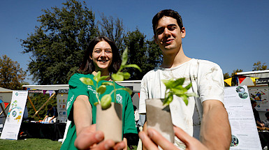 Dos jóvenes muestran unas plantas pequeñas.