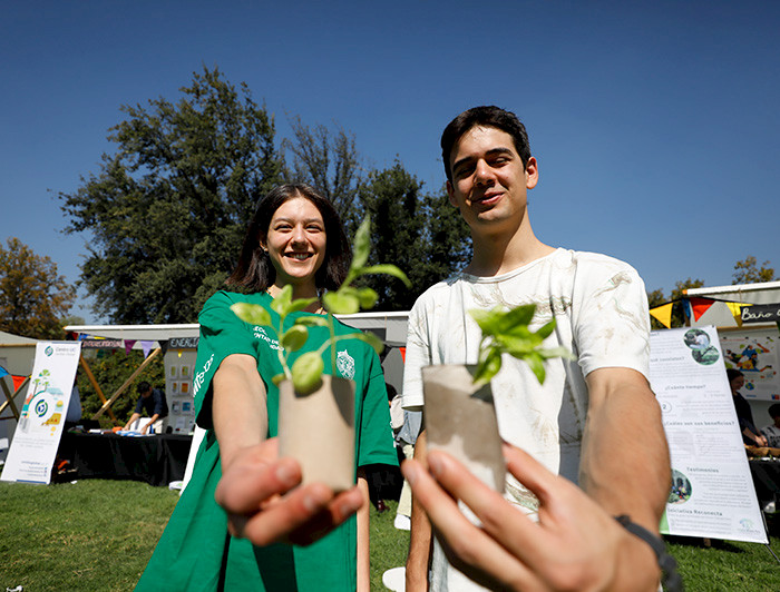 Dos jóvenes muestran unas plantas pequeñas.