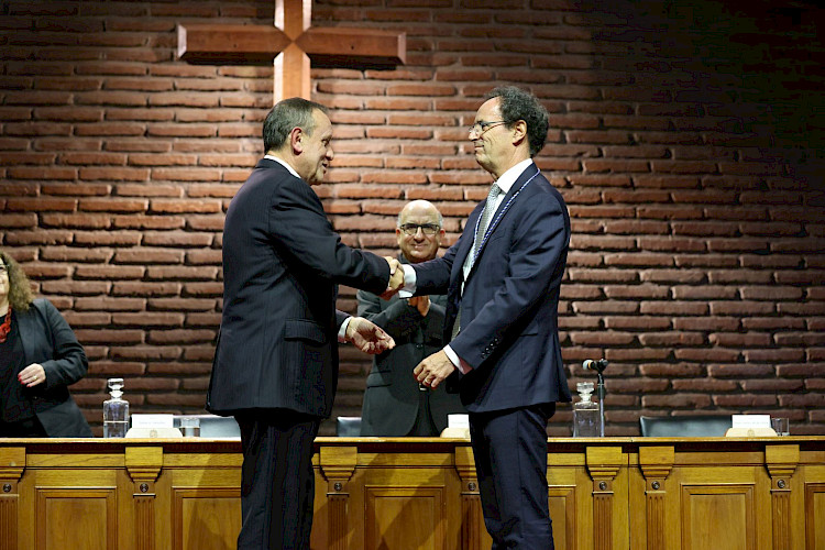 El rector saliente Ignacio Sánchez felicita al nuevo rector Juan Carlos De la Llera, tras entregarle la medalla rectoral.