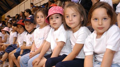 Niños sentados en un gimnasio.