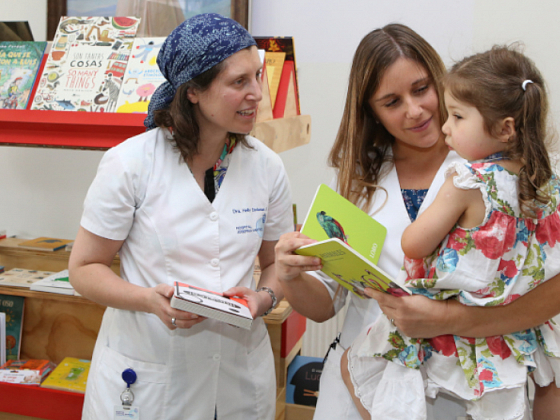 Mujer cuenta cuentos a niños que participan de la Biblioteca Escolar Futuro en el Hospital Josefina Martínez